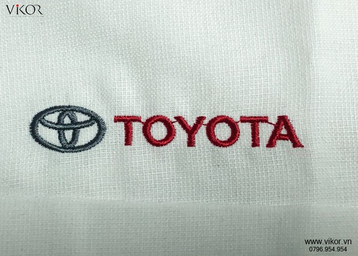 Logo Toyoya được thêu chữ màu đỏ trên nền vải trắng